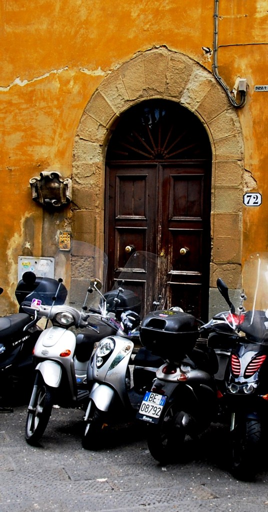 Firenze: motor bikes parked in front of an ancient door.